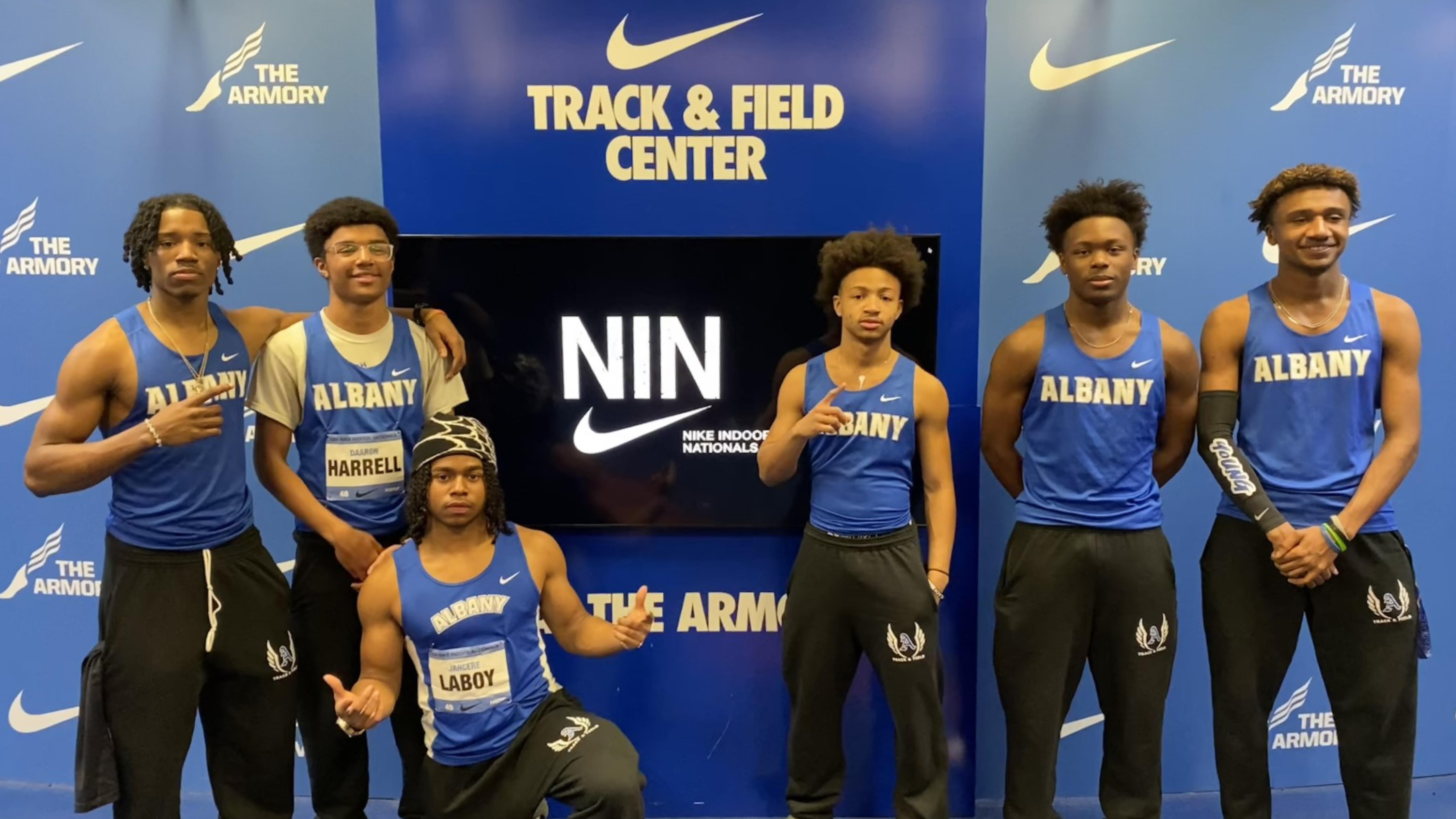 ʿ High track members posing for a photo in front of the Nike backdrop