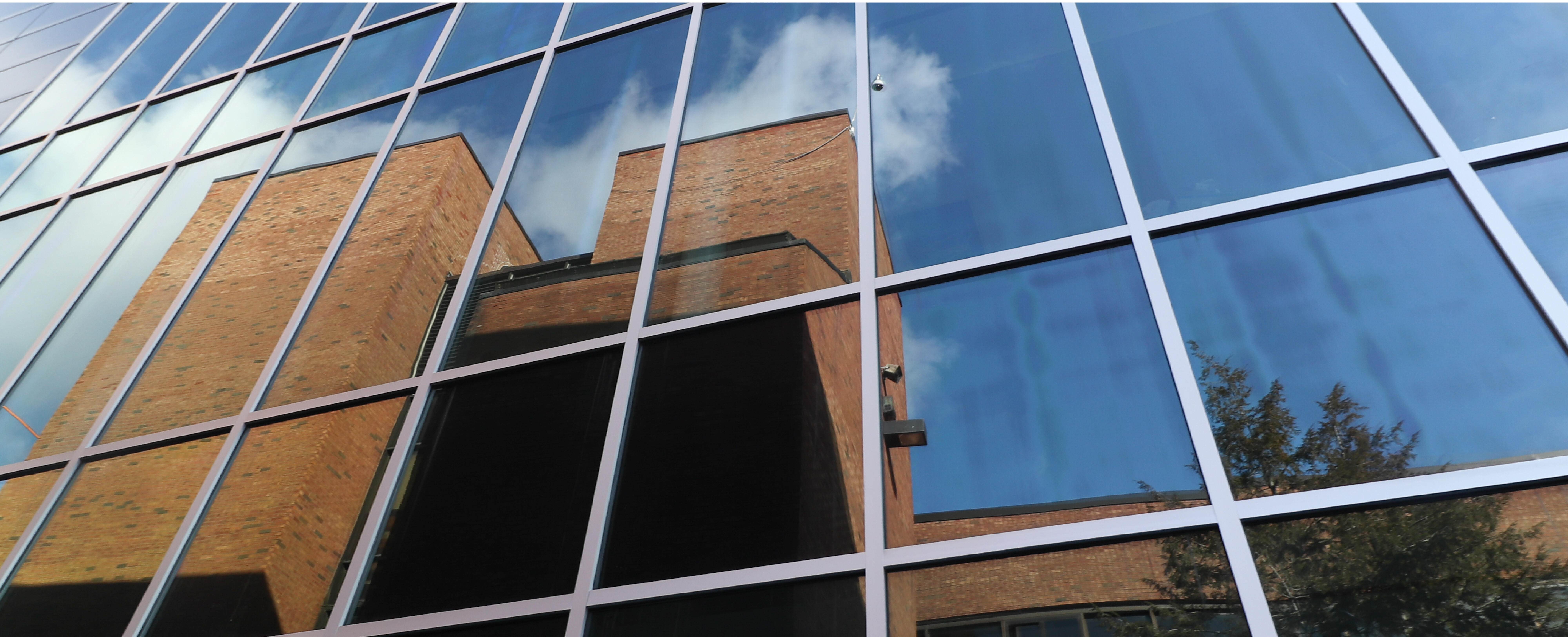 Photo of old ʿ High reflected in the glass of the new academic building